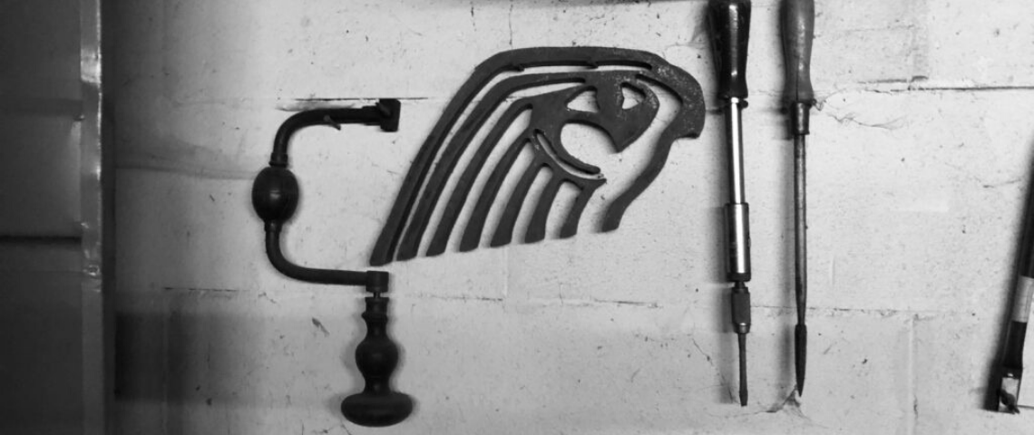 (image) photo en noir et blanc d'outils sur un établi avec l'ancien logo horus